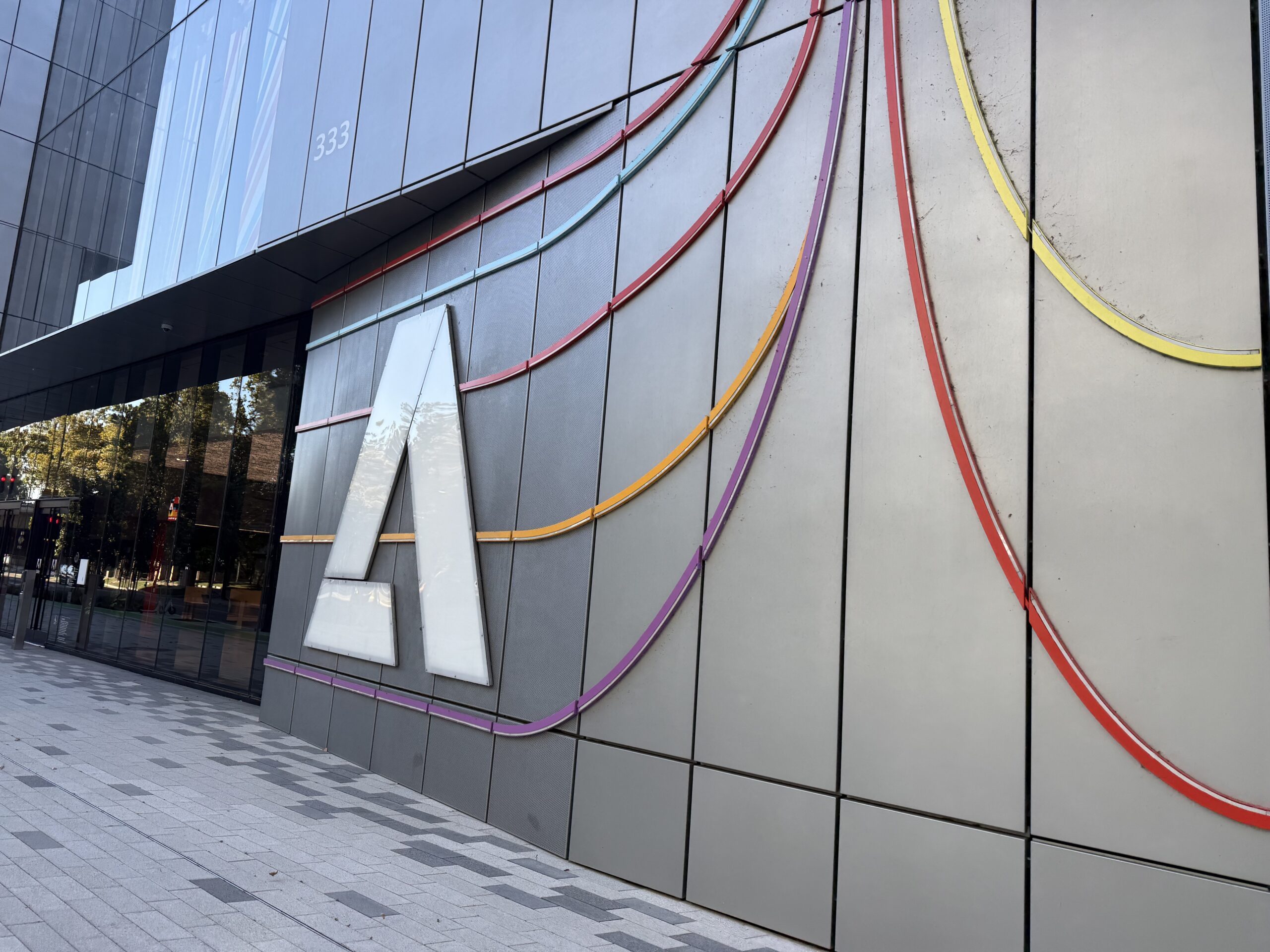 Modern building facade with a large white A, colorful curved lines, and 333 above a glass entrance.